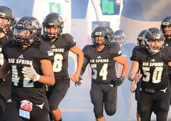 A football team running onto the field